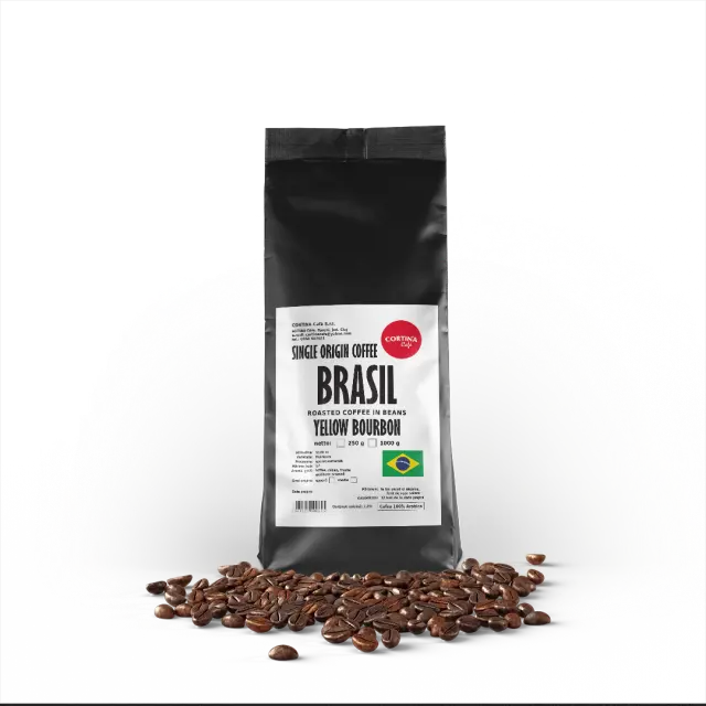 O pungă neagră de cafea boabe Cortina Cafe Brasil Yellow Bourbon, single origin, cu boabe de cafea împrăștiate în față.