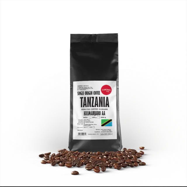Ambalaj negru cu etichetă albă pentru cafea boabe Tanzania Kilimanjaro AA, cu o grămadă de boabe în față.