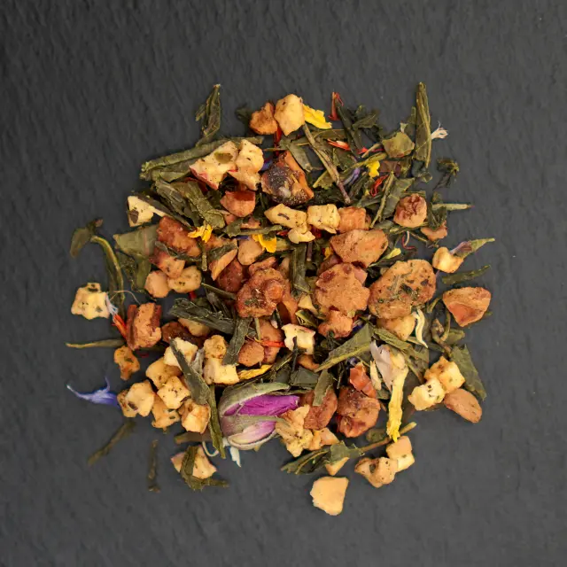 Un amestec de ceai verde Morning Green, cu frunze uscate, bucăți de fructe, petale de flori și un boboc de trandafir roz.